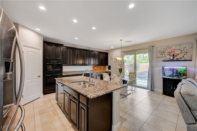7311 Spring Flower Ave, Las Vegas, NV 89117 - kitchen with stainless steel fridge, open floor plan, light tile patterned floors, light stone countertops, and a center island with sink