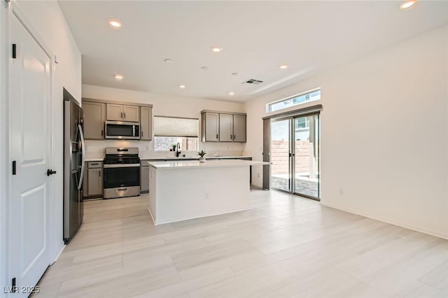 5804 Gossamer Stone Ct, Las Vegas, NV 89141 - kitchen featuring stainless steel appliances, gray cabinetry, healthy amount of natural light, a center island, and recessed lighting