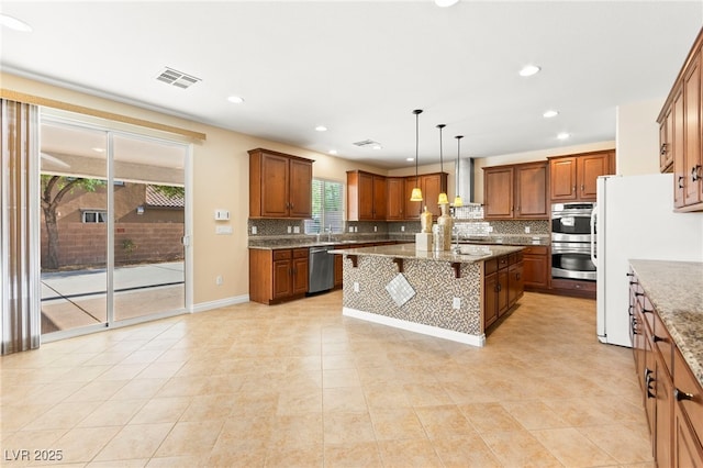2755 Asgard Ave, Las Vegas, NV 89121 - kitchen featuring stainless steel appliances, backsplash, a breakfast bar, brown cabinetry, and a kitchen island