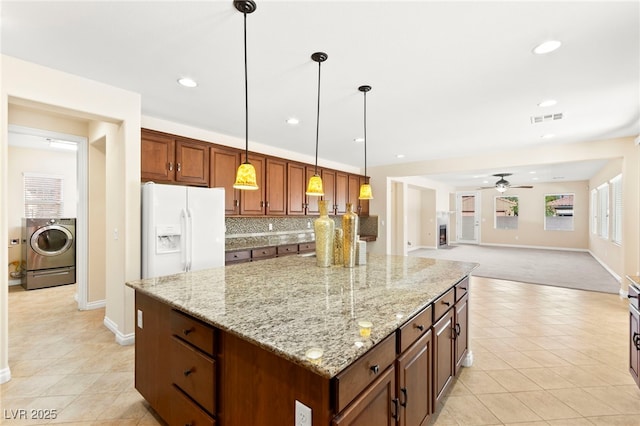 2755 Asgard Ave, Las Vegas, NV 89121 - kitchen featuring white refrigerator with ice dispenser, washer / dryer, light tile patterned flooring, a kitchen island, and ceiling fan