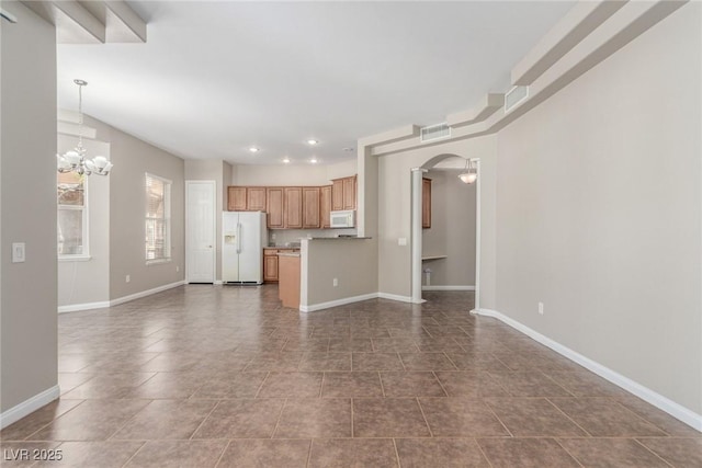 224 Morgyn Ln Unit 6, Boulder City, NV 89005 - unfurnished living room with a chandelier, arched walkways, recessed lighting, and dark tile patterned flooring