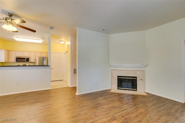 5250 S Rainbow Blvd Unit 2101, Las Vegas, NV 89118 - unfurnished living room with light wood finished floors, a ceiling fan, and a high end fireplace