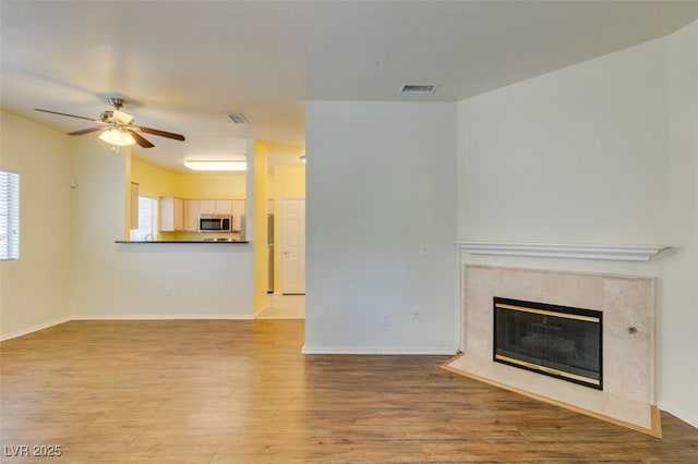 5250 S Rainbow Blvd Unit 2101, Las Vegas, NV 89118 - unfurnished living room with a ceiling fan, wood finished floors, and a premium fireplace