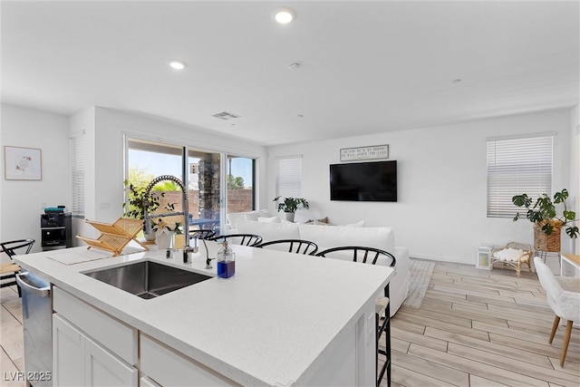 55 Strada Fontana, Henderson, NV 89011 - kitchen with open floor plan, an island with sink, white cabinetry, a breakfast bar, and recessed lighting