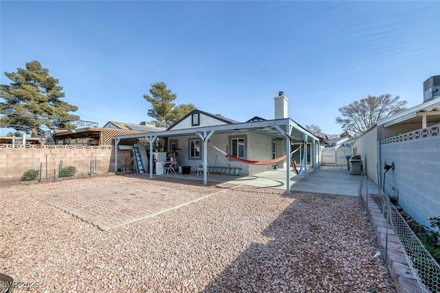 59 N Christy Ln, Las Vegas, NV 89110 - rear view of property with a fenced backyard, a chimney, and a patio area