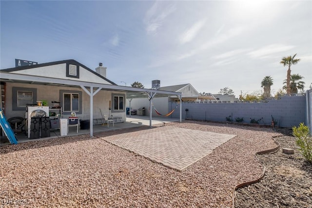 59 N Christy Ln, Las Vegas, NV 89110 - back of house featuring a fenced backyard, a patio, stucco siding, and a chimney