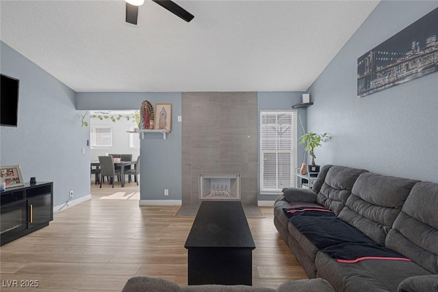 59 N Christy Ln, Las Vegas, NV 89110 - living area with wood finished floors, a ceiling fan, a textured wall, and a tiled fireplace