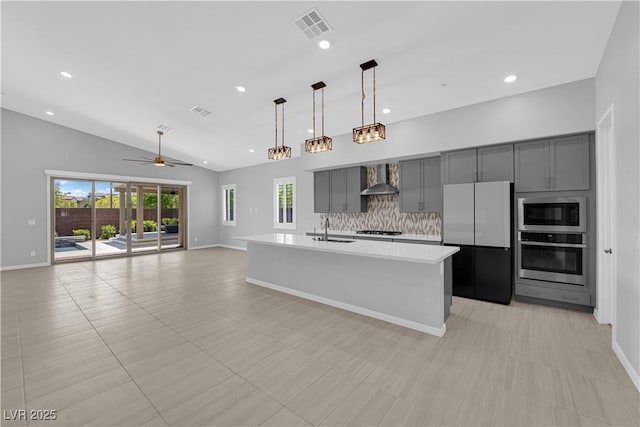 11909 Pippa Ave, Las Vegas, NV 89138 - kitchen featuring stainless steel oven, freestanding refrigerator, wall chimney exhaust hood, gray cabinets, and cooktop