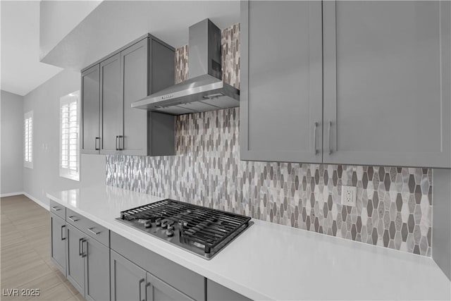 11909 Pippa Ave, Las Vegas, NV 89138 - kitchen with wall chimney exhaust hood, stainless steel gas stovetop, gray cabinetry, light countertops, and tasteful backsplash