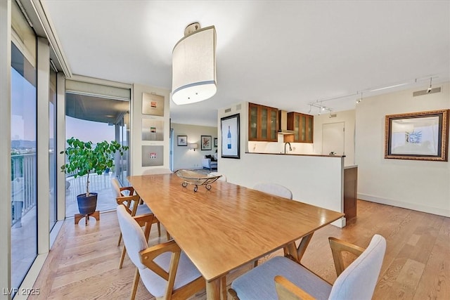 3111 Bel Air Dr Unit 7D, Las Vegas, NV 89109 - dining area with light wood-style floors and rail lighting