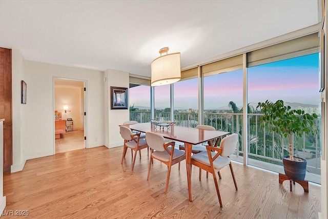 3111 Bel Air Dr Unit 7D, Las Vegas, NV 89109 - dining area with a wall of windows and light wood finished floors