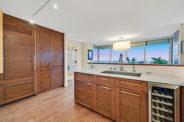 3111 Bel Air Dr Unit 7D, Las Vegas, NV 89109 - kitchen with beverage cooler, light wood finished floors, track lighting, and light countertops