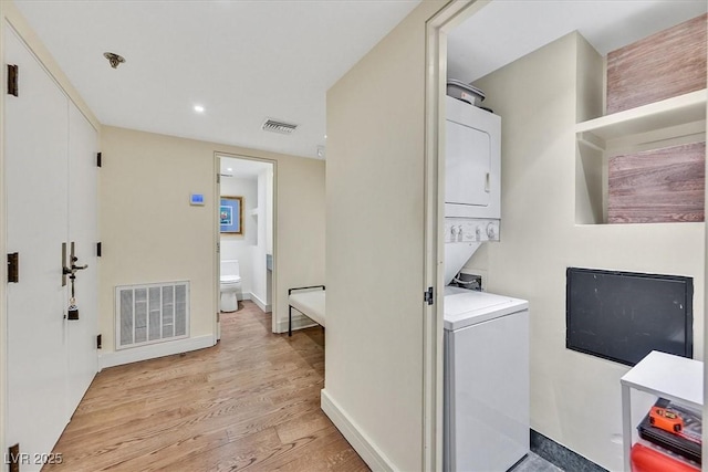 3111 Bel Air Dr Unit 7D, Las Vegas, NV 89109 - laundry room with stacked washer / drying machine, light wood-type flooring, and recessed lighting