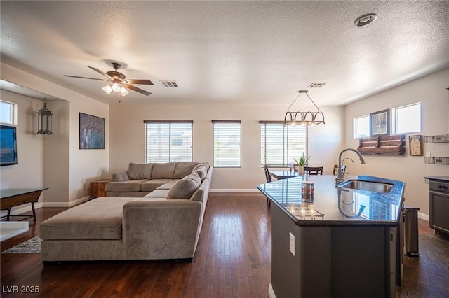 7021 Salt Marsh Ct, Las Vegas, NV 89148 - living room featuring healthy amount of natural light, dark wood-style flooring, ceiling fan, and a textured ceiling