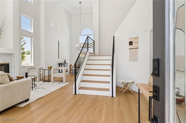 2469 Sun Reef Rd, Las Vegas, NV 89128 - entryway with a high ceiling, light wood finished floors, stairs, and a fireplace