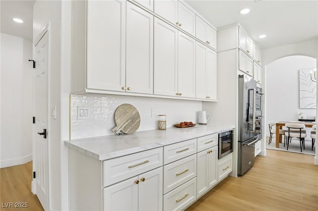 2469 Sun Reef Rd, Las Vegas, NV 89128 - kitchen featuring high quality fridge, arched walkways, light wood-style floors, recessed lighting, and backsplash
