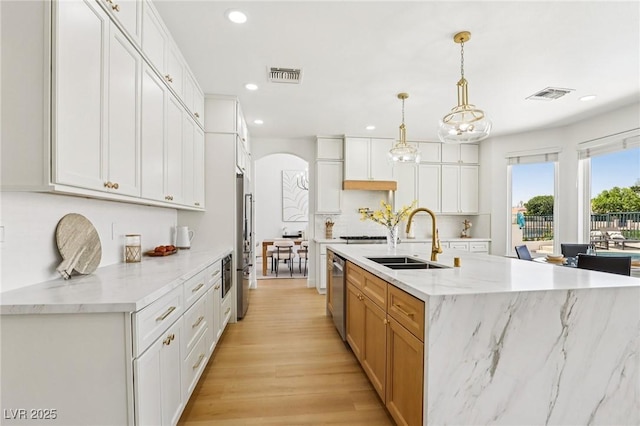 2469 Sun Reef Rd, Las Vegas, NV 89128 - kitchen with arched walkways, recessed lighting, appliances with stainless steel finishes, backsplash, and light wood-style flooring
