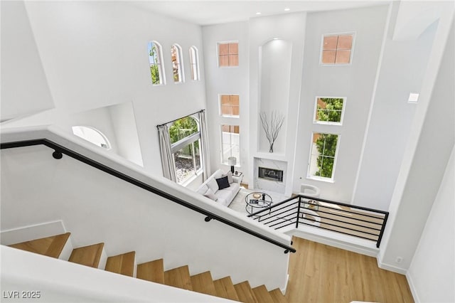 2469 Sun Reef Rd, Las Vegas, NV 89128 - staircase with a towering ceiling, wood finished floors, a premium fireplace, and recessed lighting
