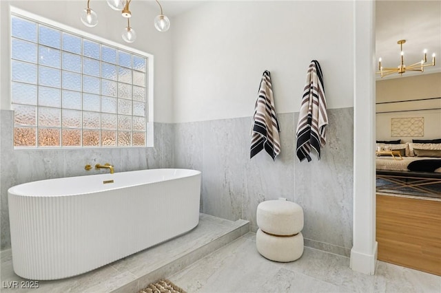 2469 Sun Reef Rd, Las Vegas, NV 89128 - bathroom with a chandelier, a freestanding bath, and wainscoting