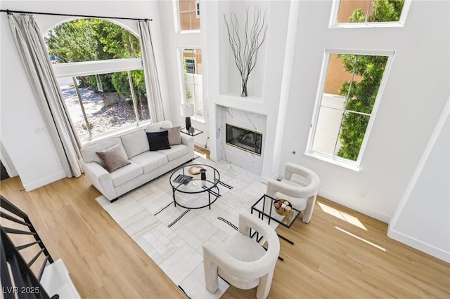2469 Sun Reef Rd, Las Vegas, NV 89128 - living room featuring wood finished floors, plenty of natural light, a premium fireplace, and a high ceiling