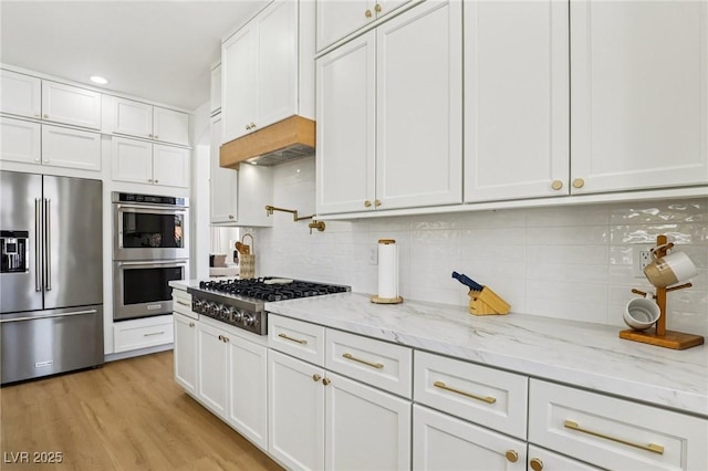 2469 Sun Reef Rd, Las Vegas, NV 89128 - kitchen featuring appliances with stainless steel finishes, white cabinets, backsplash, custom range hood, and light stone countertops