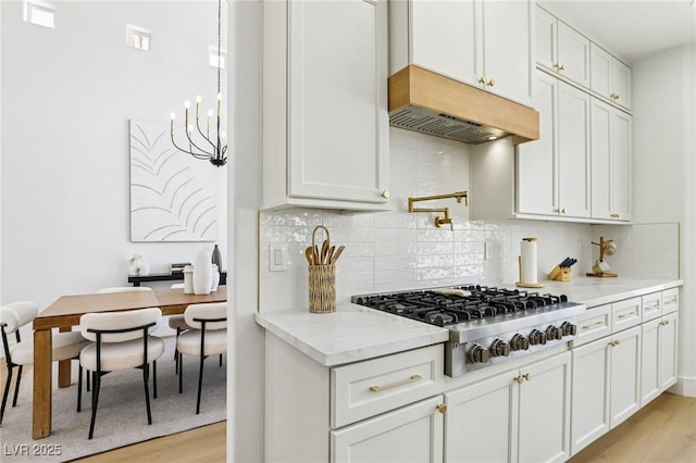 2469 Sun Reef Rd, Las Vegas, NV 89128 - kitchen featuring stainless steel gas cooktop, under cabinet range hood, light wood finished floors, light stone counters, and tasteful backsplash