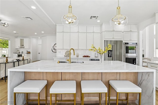 2469 Sun Reef Rd, Las Vegas, NV 89128 - kitchen with appliances with stainless steel finishes, white cabinetry, light wood-type flooring, backsplash, and recessed lighting