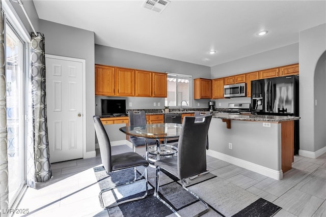 4435 Peaceful Harbor St, Las Vegas, NV 89129 - kitchen with appliances with stainless steel finishes, brown cabinets, a kitchen island, recessed lighting, and stone counters