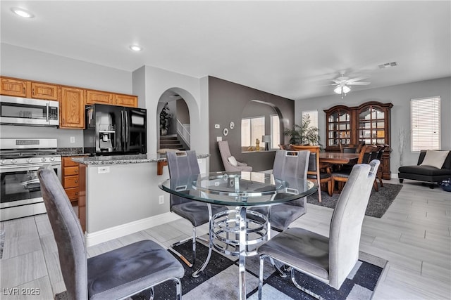 4435 Peaceful Harbor St, Las Vegas, NV 89129 - dining space with arched walkways, ceiling fan, recessed lighting, stairs, and light wood-style flooring