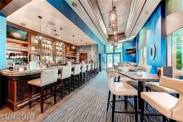 135 E Harmon Ave Unit 1703, Las Vegas, NV 89109 - community bar area featuring a tray ceiling, crown molding, decorative light fixtures, and tile patterned flooring