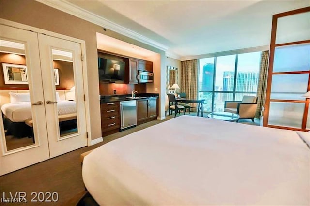 135 E Harmon Ave Unit 1703, Las Vegas, NV 89109 - bedroom featuring crown molding, french doors, a wall of windows, bar area, and dark colored carpet