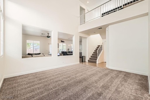 10413 Rising Harbor Ave, Las Vegas, NV 89129 - unfurnished living room with carpet, stairway, and a ceiling fan