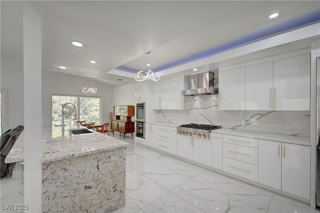 2851 Queens Courtyard Dr, Las Vegas, NV 89109 - kitchen featuring wall chimney range hood, stainless steel appliances, recessed lighting, modern cabinets, and a raised ceiling