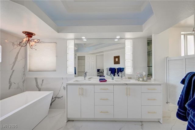 2851 Queens Courtyard Dr, Las Vegas, NV 89109 - full bath featuring a tray ceiling, marble finish flooring, double vanity, a soaking tub, and recessed lighting