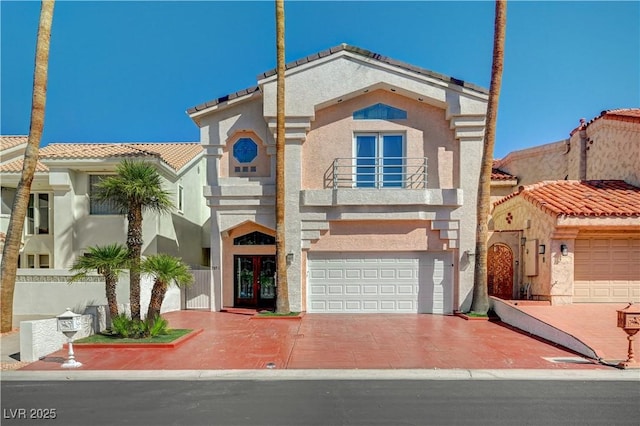 2851 Queens Courtyard Dr, Las Vegas, NV 89109 - view of front of home featuring french doors, a balcony, stucco siding, a garage, and driveway