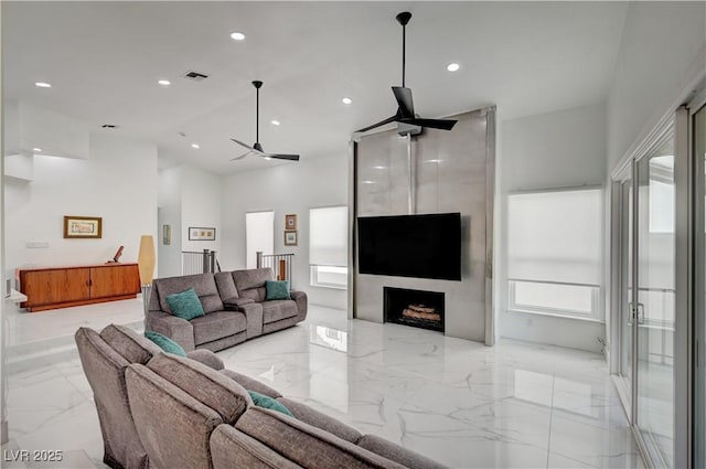 2851 Queens Courtyard Dr, Las Vegas, NV 89109 - living room featuring light marble finish flooring, recessed lighting, a ceiling fan, a towering ceiling, and a large fireplace