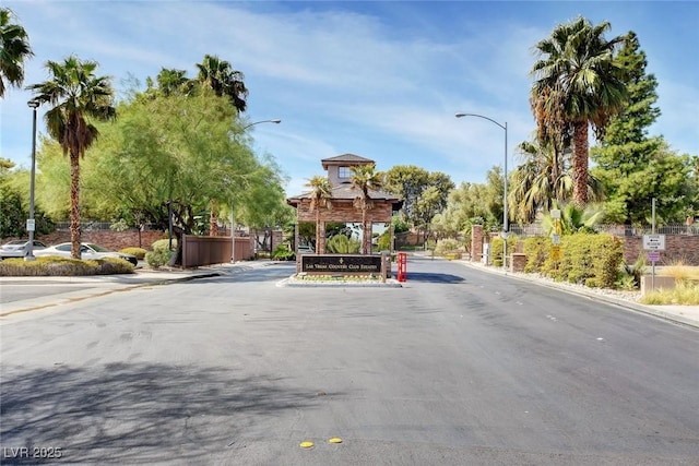2851 Queens Courtyard Dr, Las Vegas, NV 89109 - view of asphalt road with street lights, curbs, sidewalks, and a gated entry