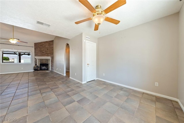 2950 Winchester Ave, Pahrump, NV 89048 - unfurnished living room with ceiling fan, arched walkways, and a stone fireplace
