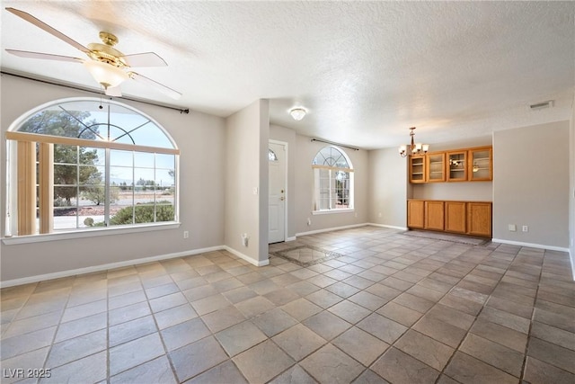 2950 Winchester Ave, Pahrump, NV 89048 - unfurnished living room featuring a chandelier, a textured ceiling, a ceiling fan, and tile patterned floors
