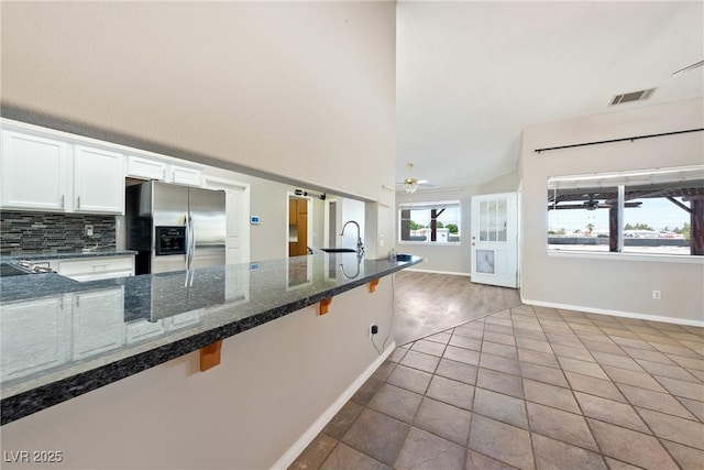 2950 Winchester Ave, Pahrump, NV 89048 - kitchen with stainless steel refrigerator with ice dispenser, tasteful backsplash, white cabinetry, a ceiling fan, and dark stone counters