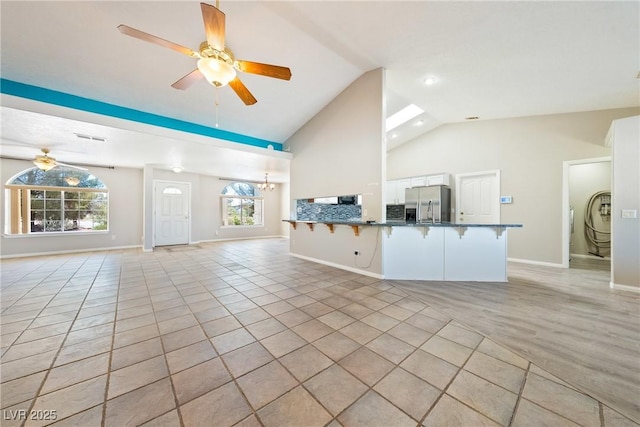 2950 Winchester Ave, Pahrump, NV 89048 - unfurnished living room with ceiling fan, plenty of natural light, high vaulted ceiling, and washer / clothes dryer