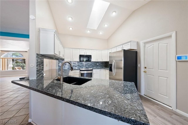 2950 Winchester Ave, Pahrump, NV 89048 - kitchen with appliances with stainless steel finishes, a peninsula, white cabinetry, tasteful backsplash, and recessed lighting