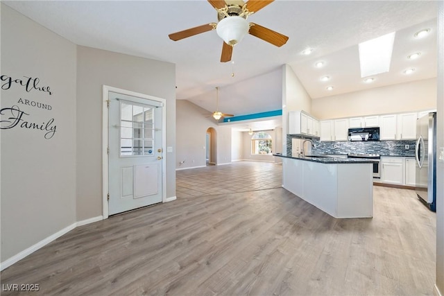 2950 Winchester Ave, Pahrump, NV 89048 - kitchen featuring appliances with stainless steel finishes, open floor plan, dark countertops, ceiling fan, and arched walkways