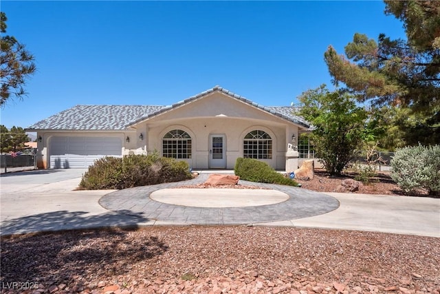 2950 Winchester Ave, Pahrump, NV 89048 - view of front of house featuring curved driveway, stucco siding, and an attached garage