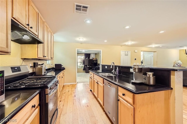 3168 Via Festiva, Henderson, NV 89044 - kitchen featuring appliances with stainless steel finishes, under cabinet range hood, dark countertops, light wood-style floors, and recessed lighting