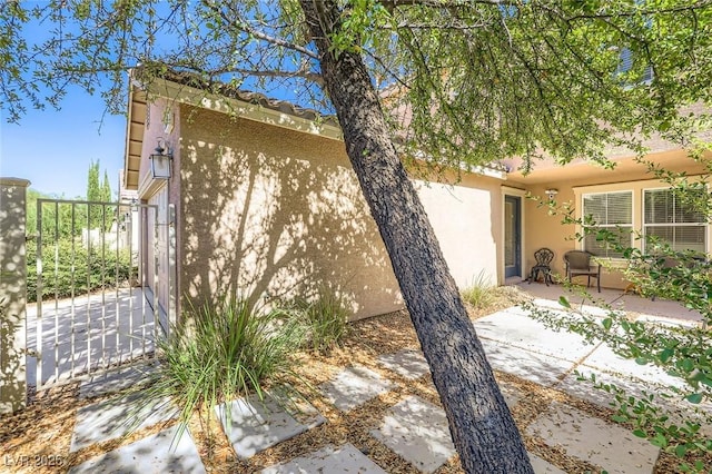 3168 Via Festiva, Henderson, NV 89044 - view of side of home featuring stucco siding and a patio area