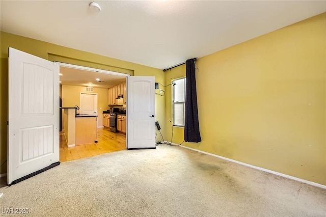 3168 Via Festiva, Henderson, NV 89044 - unfurnished living room featuring light colored carpet and baseboards