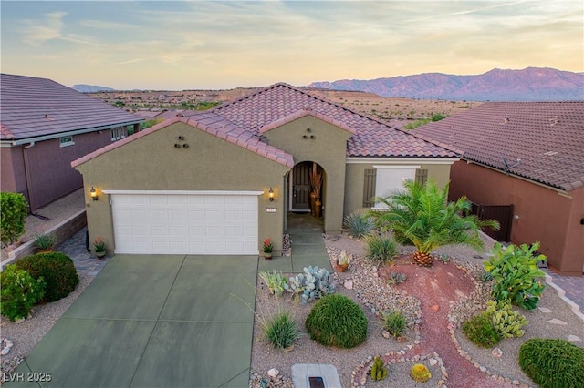 757 Bridle Path Ln, Mesquite, NV 89034 - mediterranean / spanish-style home featuring a tile roof, an attached garage, stucco siding, driveway, and a mountain view