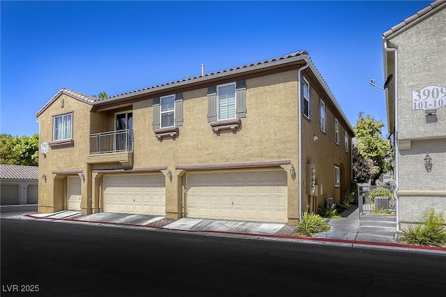 3905 Sweet Pine St Unit 102, Las Vegas, NV 89108 - view of property featuring stucco siding, a garage, and a tile roof