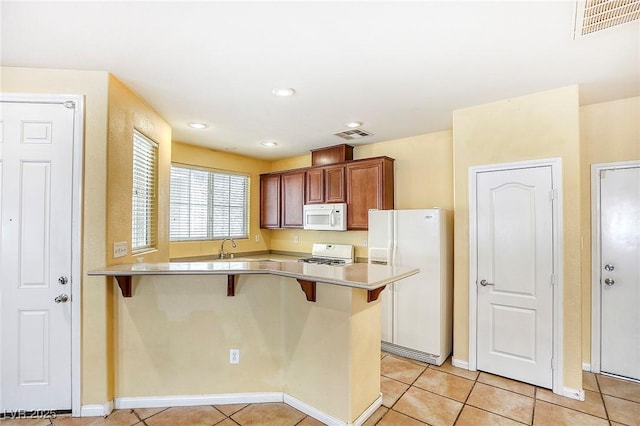 3905 Sweet Pine St Unit 102, Las Vegas, NV 89108 - kitchen with white appliances, a breakfast bar area, light countertops, and recessed lighting